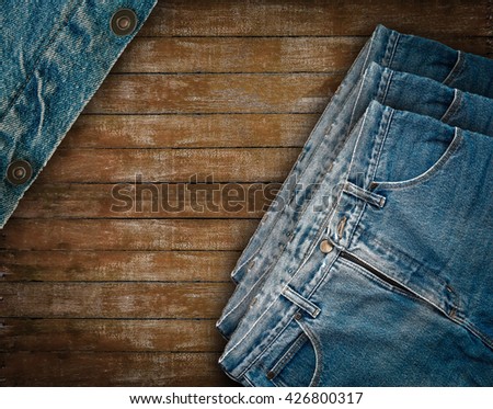 Denim jeans on grunge wooden background.