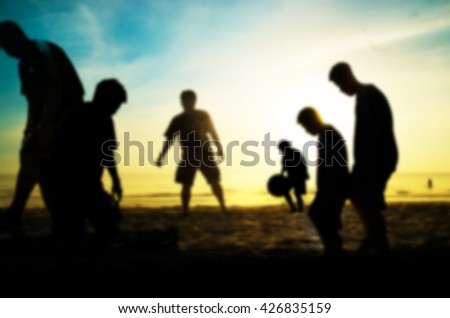  silhouette of man play soccer on the beach with blur style