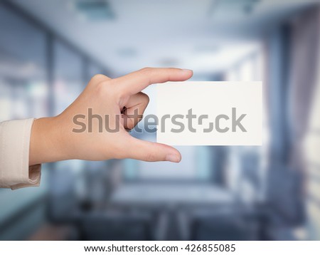 hand holding blank namecard with office background