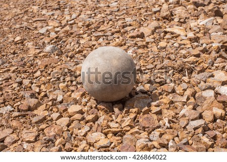 Very old soccer ball on the brown ground  