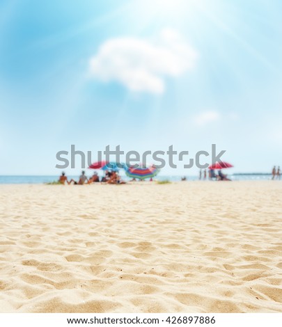 sand on beach closeup and sun in blue  sky. soft focus on bottom of picture