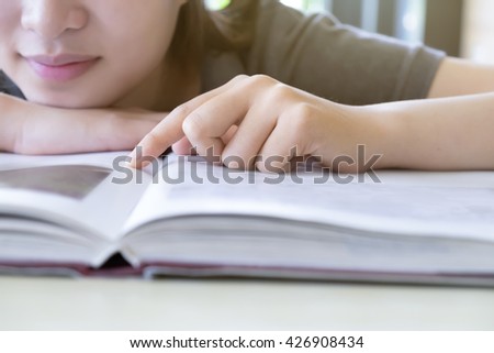 Woman reading book in library. Education concept background. Retro filter effect,soft focus,low light.(selective focus)