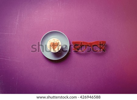 blue cup of coffee and glasses on the purple background