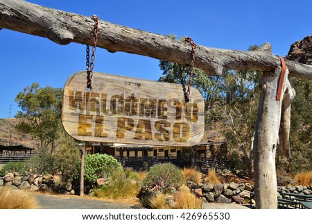 old wood signboard with text " welcome to El Paso" hanging on a branch