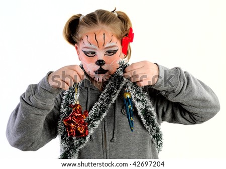 Girl with drawing by mask tiger with decorations Christmas tree