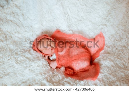 Newborn is sleeping in the orange blanket