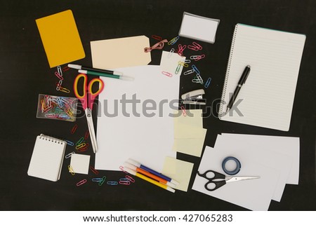 Top view of white blank paper surrounded with school or office equipment