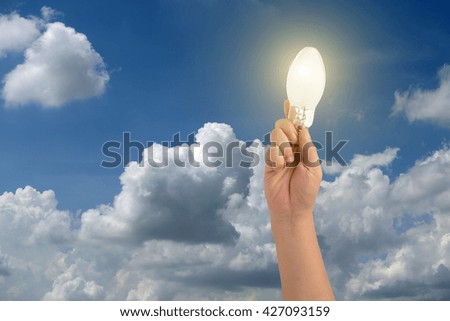 idea concept hand holding led lamp on sky-clouds background.
