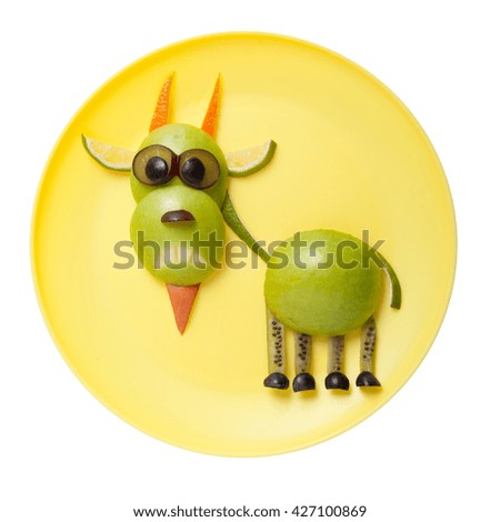 Funny goat made of green fruits on plate