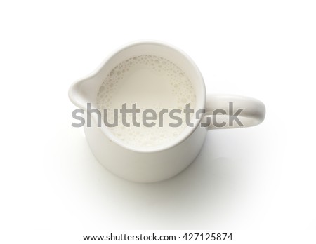 Top view of milk jug with milk on the white Royalty-Free Stock Photo #427125874