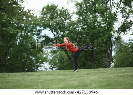 Picture of young beautiful sport woman training in green park or forest. Blond lady in red jacket stretching and resting.