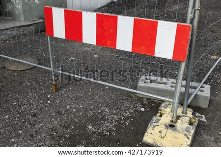 Striped red and white urban road barrier