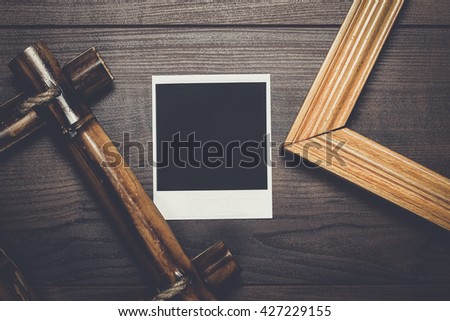 empty frames and old photo on the wooden table