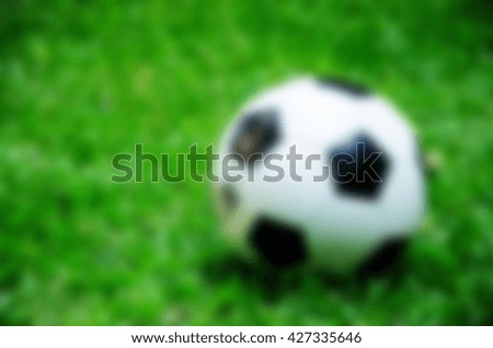 black and white football on grass with blur 