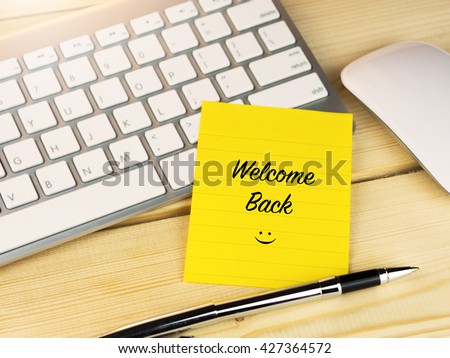 Welcome back with smiley on work table Royalty-Free Stock Photo #427364572