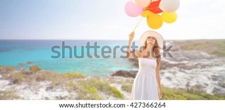 travel, tourism, summer, holidays and people concept - smiling young woman wearing sunglasses with balloons over exotic tropical beach and sea background