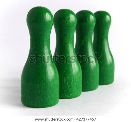 Photo shows four green wooden bowling pins 