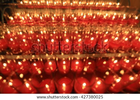Church candles in red transparent chandeliers