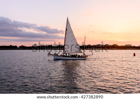 Boat on channel taking sea at sunset