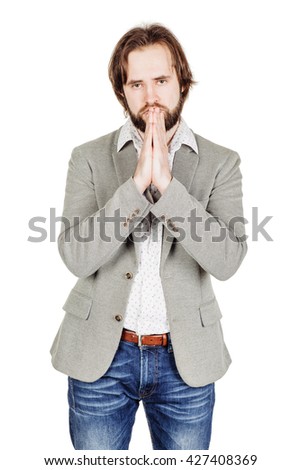 portrait of bearded business man praying with hands. human emotion expression and lifestyle concept. image on a white studio background.