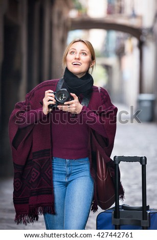 Positive happy woman looking curious and taking pictures outdoors