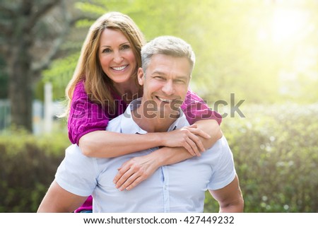 Portrait Of Happy Woman Embracing Her Husband From Behind