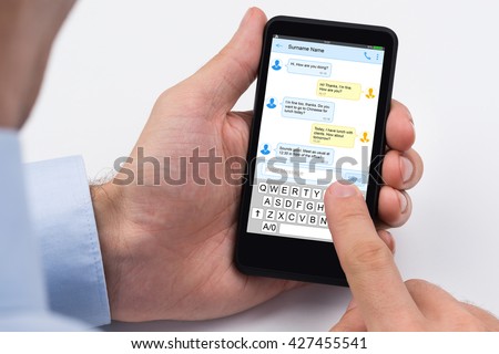Close-up Of A Person Sending Text Message Using Mobile Phone Royalty-Free Stock Photo #427455541