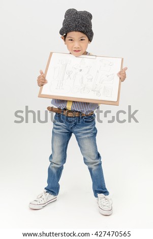 Happy Asian little artist boy holding a blank art board  on gray background