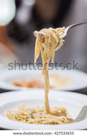Swirls of cooked spaghetti with fork
