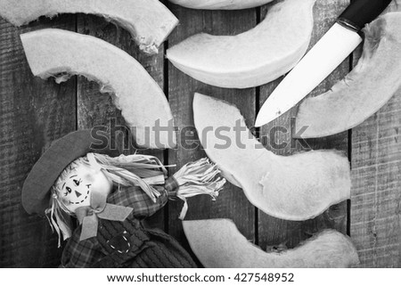 cut pumpkin and scarecrow on a wooden background