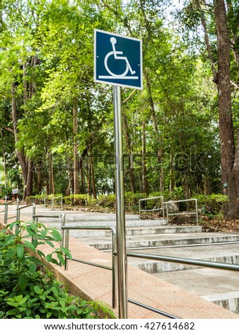 white and blue wheelchair ramp sign in the park.