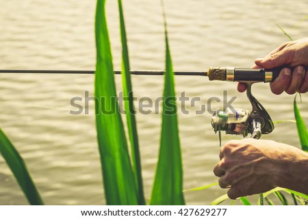 Fisherman with a fishing rod on the river bank