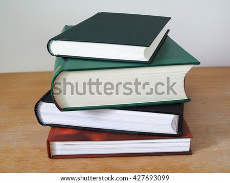 Stack of multi colored books on wooden table. Education concept.