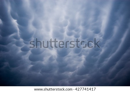 Dark cirrocumulus clouds texture in the blue sky against the sun background image