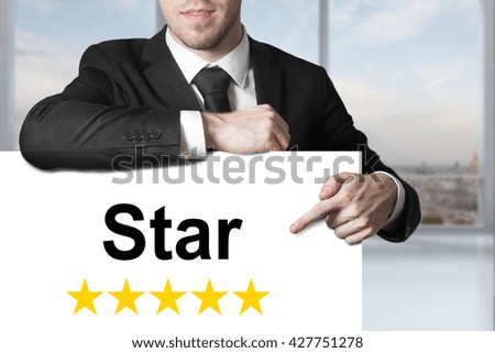 businessman in black suit pointing on white sign star golden rating