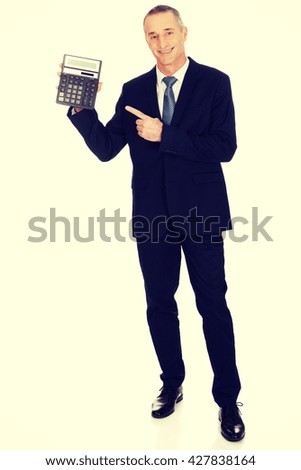 Happy businessman pointing on calculator