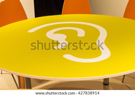 Yellow table with a picture of the human ear. The character of the hearing.