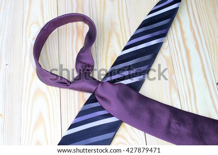 Happy Fathers Day with red, gray and black striped necktie on pime wood background