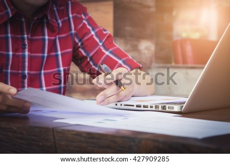Business man holding a pen and analysis data from document   vintage filter effect