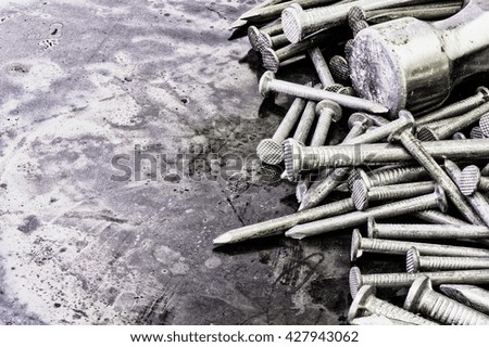 Nails and a hammer on a textured background