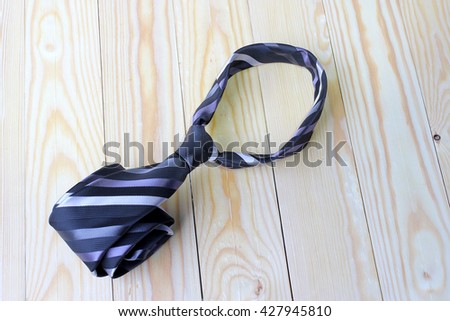 Gray and black striped necktie on pime wood background. Happy Fathers Day
