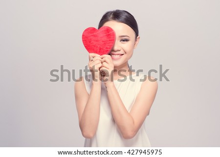 Beautiful smiling young woman offering a heart, retro colors