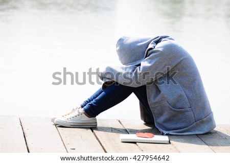 Young Woman in Desperate Sitting Near River Royalty-Free Stock Photo #427954642