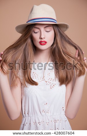 Portrait woman wearing a hat, studio picture. Young woman in bright hat, beige background. Head of a woman wearing a hat. portrait Fashion Girl .              