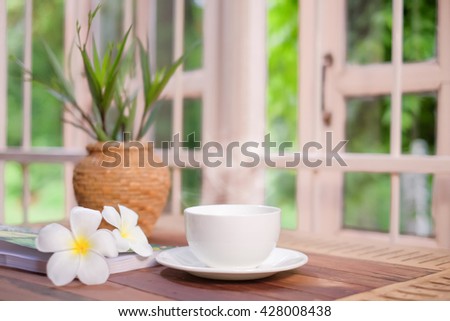a selective focus picture of a cup of coffee on the table near the window
