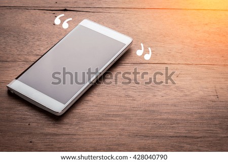 Smart phone with blank screen lying on old wooden table