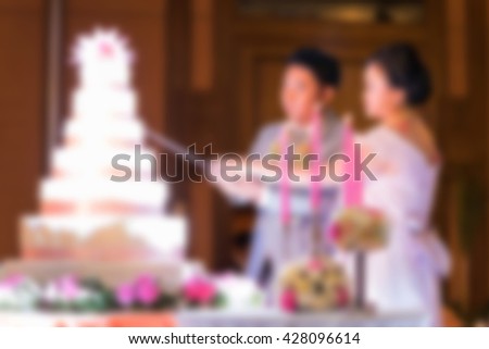 blurred image of bride and groom cutting wedding cake
