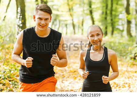 Photo of two happy young exercising outdoor runner