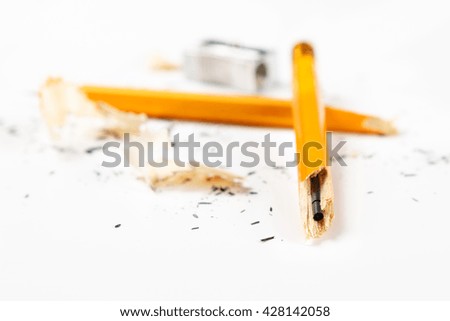 Pencil, metal sharpener and pencil shavings on white background. Horizontal image.