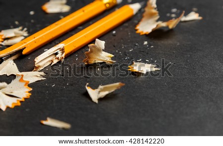 Broken pencil with shavings on black background. Horizontal image. Royalty-Free Stock Photo #428142220